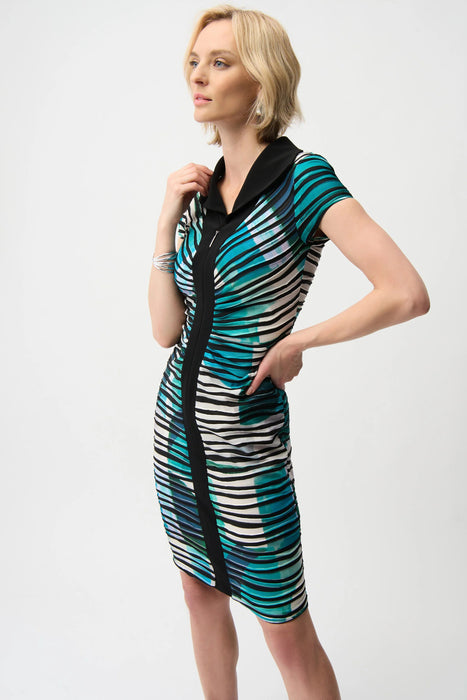 Woman wearing a green and black geometric striped sheath dress with zip front and cap sleeves from Joseph Ribkoff