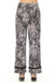 Woman wearing a snakeskin printed wide leg pant with black trim from Joseph Ribkoff