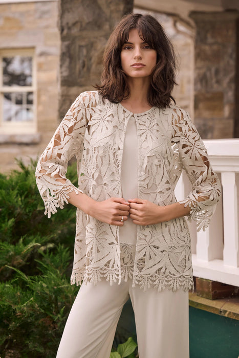 Woman wearing a neutral-toned guipure lace straight cover-up with floral detailing, styled over a matching top and pants.