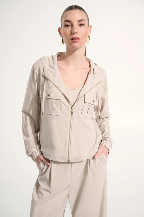 Woman wearing a hooded boxy utility jacket with a zip-front design, flap pockets, and relaxed fit for a modern casual look.