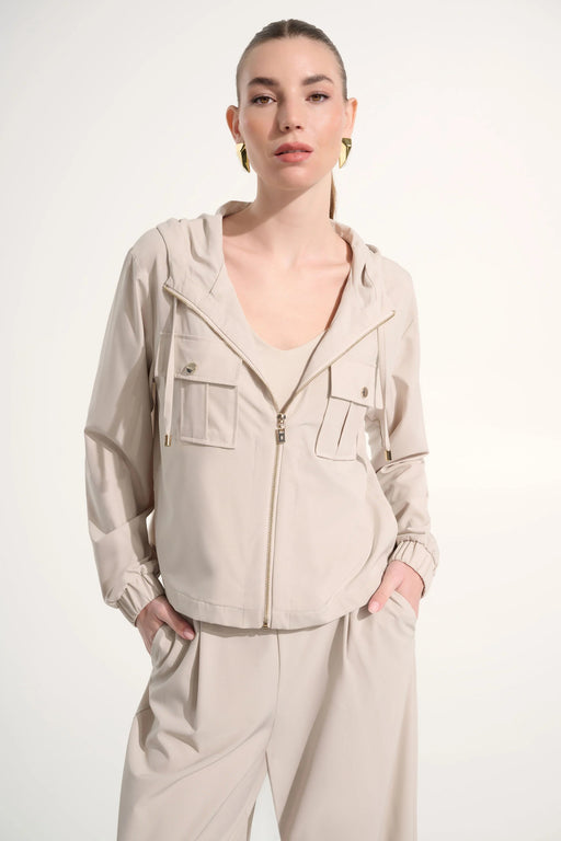 Woman wearing a hooded boxy utility jacket with a zip-front design, flap pockets, and relaxed fit for a modern casual look.