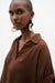 Woman wearing Joseph Ribkoff boxy top with shirred sleeves, featuring a relaxed fit silhouette, lightweight fabric, and modern elegant styling paired with wide-leg culottes.