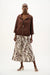 Woman wearing a mahogany funnel collar bomber jacket with a zip-up front and textured fabric, styled with rolled sleeves for a modern chic look.