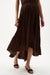 Woman wearing Joseph Ribkoff mahogany pleated satin flare skirt styled for evening dinner, resort vacation, date night, and elegant special occasions.