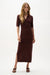 Woman wearing a mahogany viscose sweater knit straight midi dress with short sleeves, V-neck collar, and side slit detail.