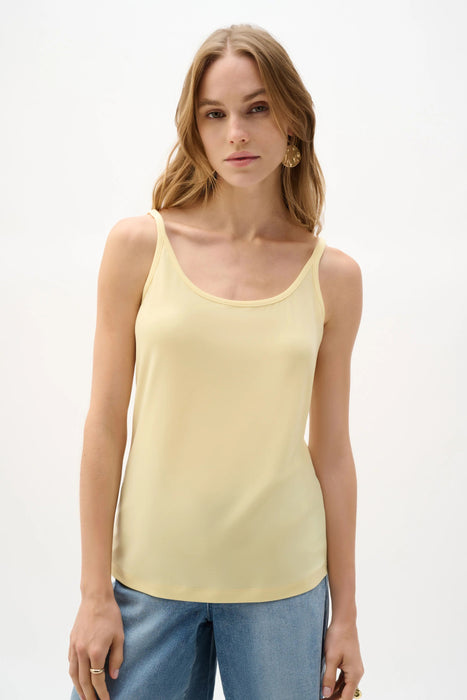 Woman wearing Joseph Ribkoff silky knit fitted camisole tank top styled for layering under blazers, sheer tops, and casual chic summer outfits.