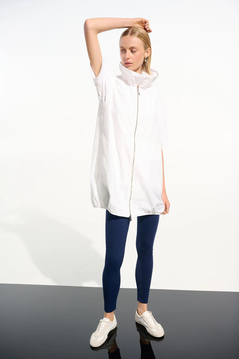Woman wearing Joseph Ribkoff Memory Cocoon Vest with shirred collar, featuring lightweight white fabric, cocoon silhouette, zip-front design, and a modern, relaxed fit.