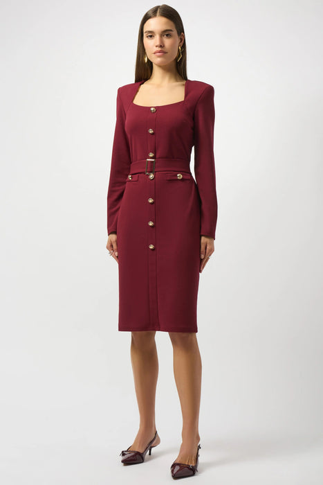 Woman wearing a burgundy knee length sheath dress with belt, square neck, and long sleeves