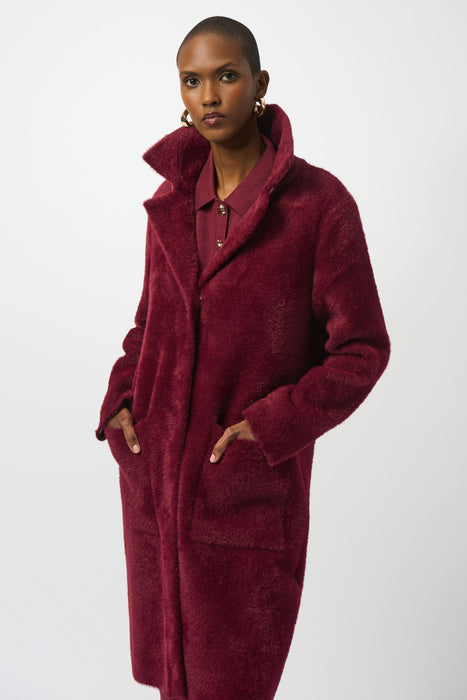 Woman wearing a red coat with detachable faux fur trim and long sleeves from Joseph Ribkoff
