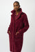 Woman wearing a red coat with detachable faux fur trim and long sleeves from Joseph Ribkoff