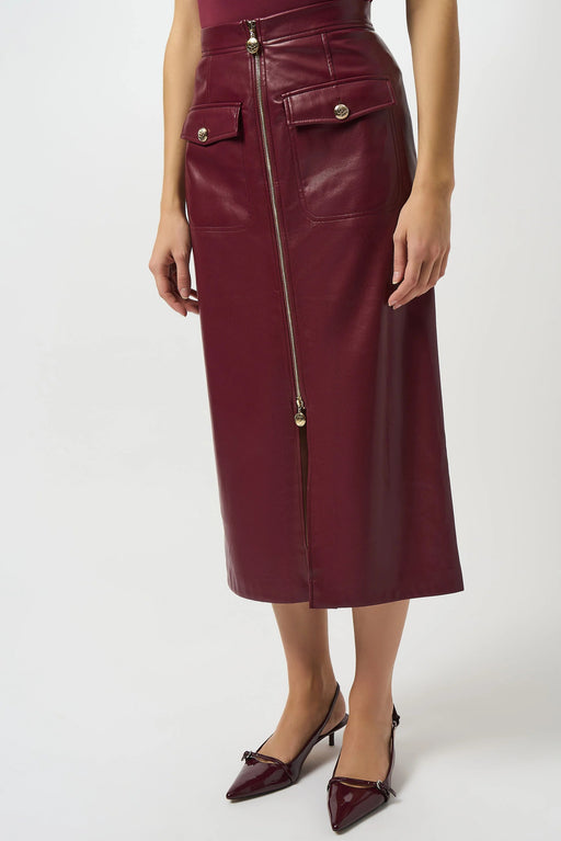 Woman wearing a burgundy leatherette midi skirt with zip front closure and front slit