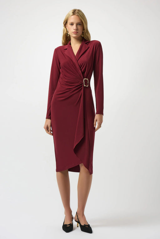 Woman wearing a burgundy knee length sheath dress with a buckle detail and wrap v-neck
