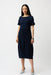 Woman wearing Joseph Ribkoff midnight blue 3D dot jacquard cocoon dress, featuring textured fabric, short sleeves, and a relaxed elegant midi silhouette.