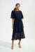 Woman wearing a dark blue midi dress with 3D floral details and waist sash from Joseph Ribkoff