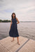 Woman wearing Joseph Ribkoff bubble skirt A-line dress, featuring a sleeveless design, midi length, voluminous hem, and a flattering elegant silhouette.