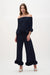 Woman wearing a Joseph Ribkoff georgette off-shoulder pleated top with cascading ruffle sleeves and sculptural peplum detail at an elegant evening event.