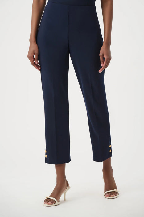 Woman wearing a dark blue cropped high waist pants with gold rose buttons at the hem from Joseph Ribkoff