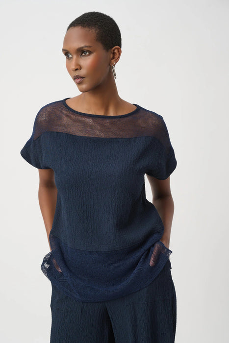 Woman wearing a dark blue textured short sleeve top with sheer mesh insert from Joseph Ribkoff