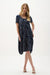 Woman wearing Joseph Ribkoff geometric print cocoon dress, featuring a relaxed silhouette, modern abstract pattern, soft drape, and a chic contemporary fit.