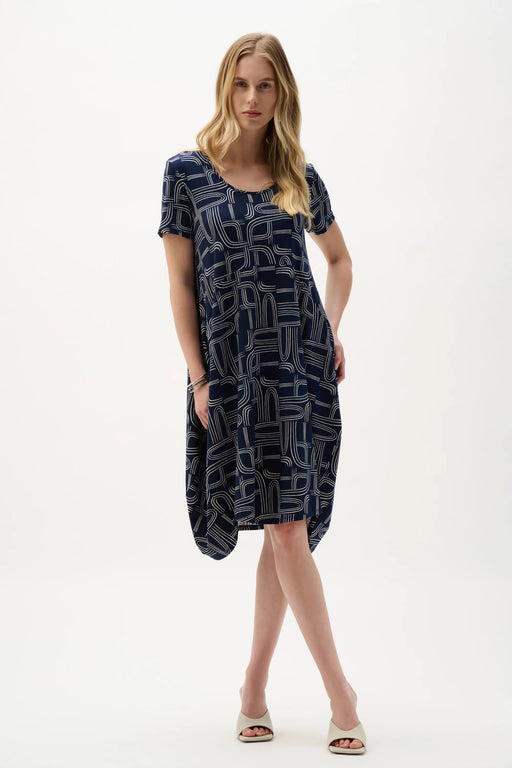 Woman wearing Joseph Ribkoff geometric print cocoon dress, featuring a relaxed silhouette, modern abstract pattern, soft drape, and a chic contemporary fit.