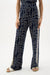 Woman wearing Joseph Ribkoff geometric print wide leg pull-on pants, featuring a bold modern pattern, flowy silhouette, elastic waistband, and a flattering elongated fit.