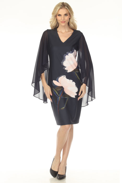 Woman wearing a dark blue floral v-neck dress with flowy chiffon cape sleeves from Joseph Ribkoff