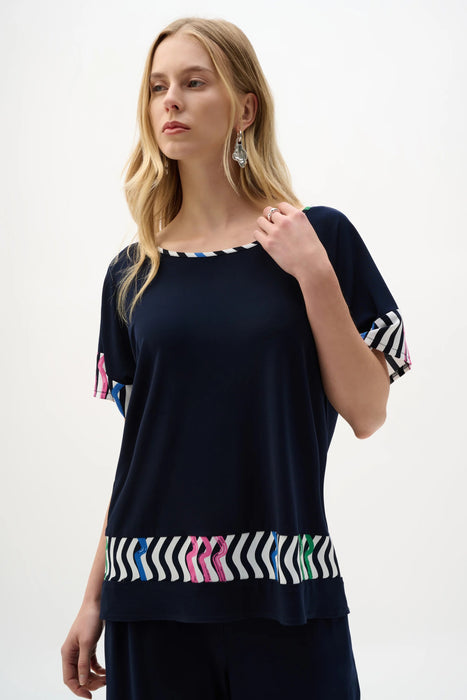 Woman wearing Joseph Ribkoff midnight blue multi stripe print boxy top styled for casual outings, office casual, travel, and modern everyday fashion looks.