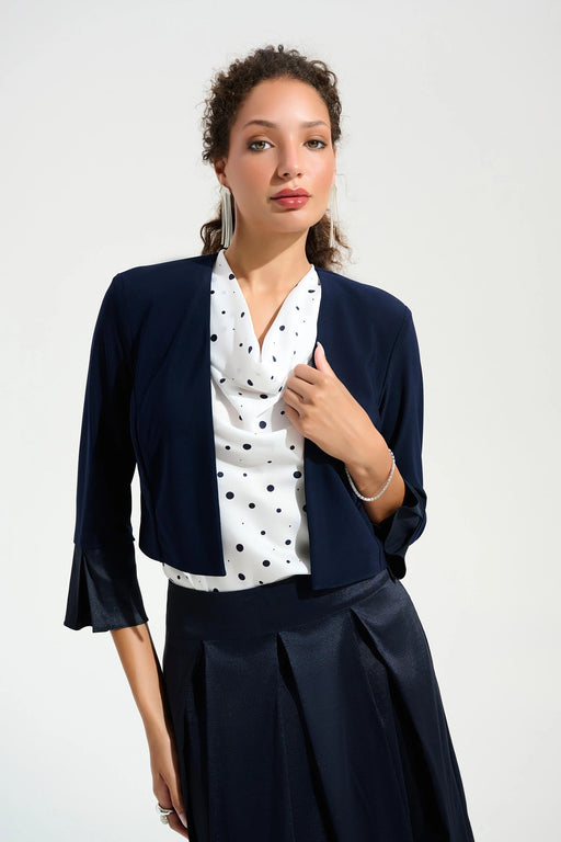 Woman wearing a dark blue open front bolero with 3/4 sleeve bell sleeves from Joseph Ribkoff