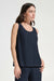 Woman wearing a dark blue pleated sleeveless top with scoop neck from Joseph Ribkoff
