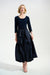 Woman wearing a dark blue 3/4 sleeve dress with pleated midi taffeta skirt from Joseph Ribkoff
