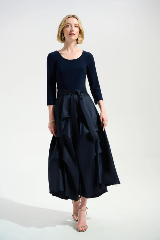 Woman wearing a dark blue 3/4 sleeve dress with pleated midi taffeta skirt from Joseph Ribkoff