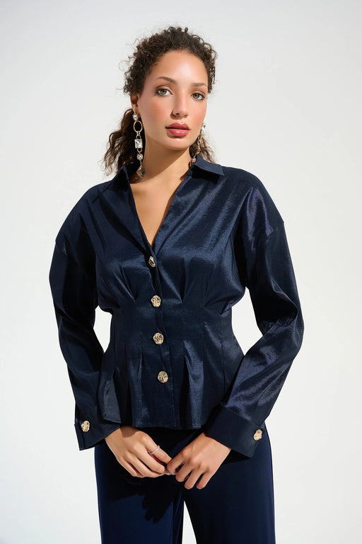 Woman wearing a dark blue pleated blouse with gold button front and long sleeves from Joseph Ribkoff