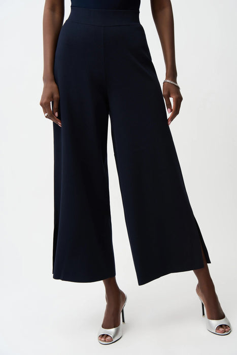 Woman wearing a dark blue cropped wide leg pants with side slit hem from Joseph Ribkoff