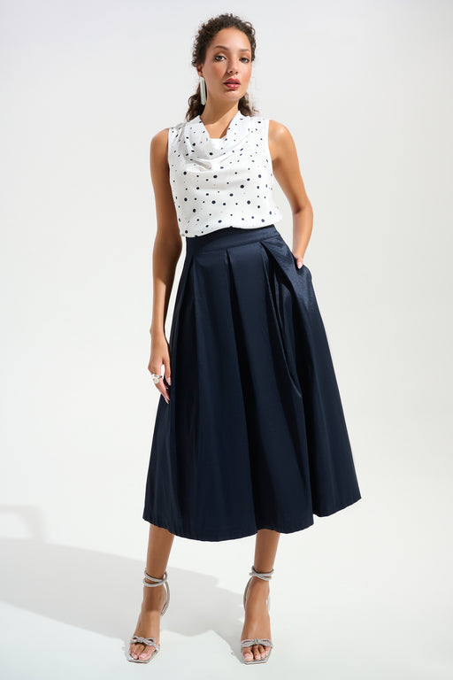 Woman wearing a dark blue pleated midi flared skirt with high waist and side pockets from Joseph Ribkoff