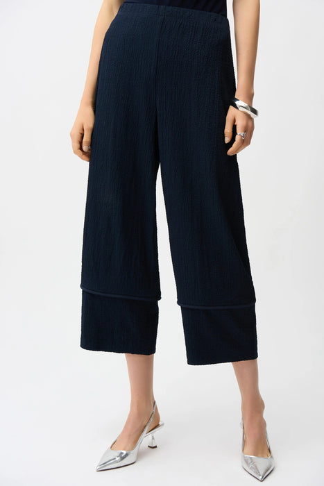 Woman wearing a navy blue textured pull on cropped pants with wide leg from Joseph Ribkoff
