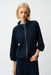 Woman wearing a navy blue zip front bomber jacket puff sleeves and mock neck from Joseph Ribkoff