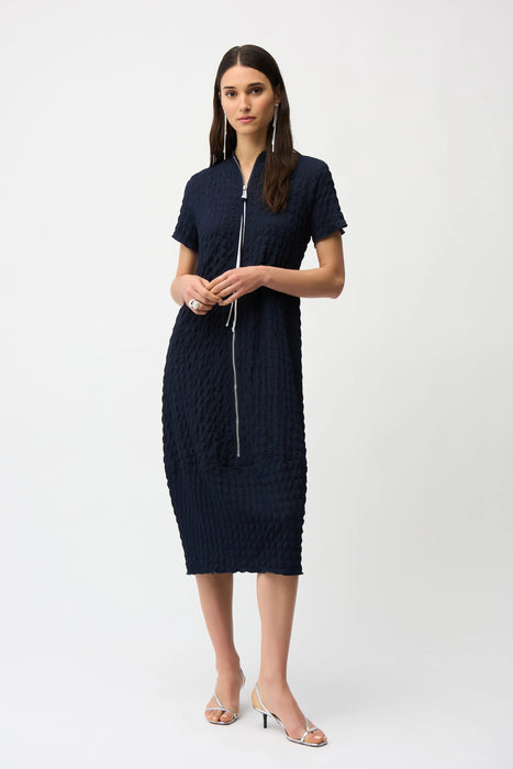 Woman wearing a dark blue bubble jacquard midi dress with zipper front and short sleeves from Joseph Ribkoff