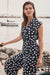Woman wearing Joseph Ribkoff midnight blue and vanilla dot wrap peplum top styled for office chic, dinner dates, summer events, and elegant casual occasions.
