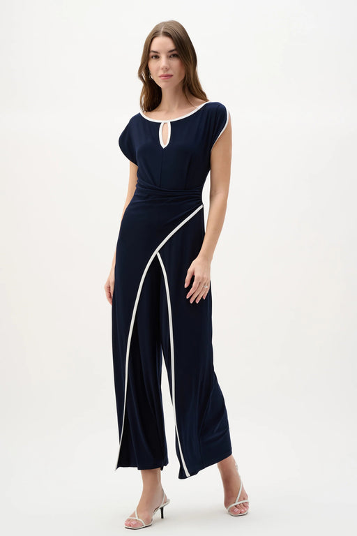 Woman wearing midnight blue culotte jumpsuit with draped bodice and contrast vanilla piping detail for an elegant evening look