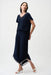 Woman wearing a dark blue one-piece wide jumpsuit with mesh insert and contrast trim at the v-neck and hem from Joseph Ribkoff