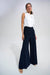 Woman wearing a two-tone one piece jumpsuit with white mock neck top and dark blue wide leg from Joseph Ribkoff