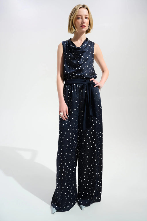 Woman wearing a dark blue wide leg pants with white polka dots and waist sash from Joseph Ribkoff