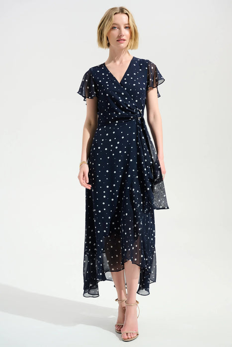 Woman wearing a dark blue polka dots wrap dress with high low ruffle hem from Joseph Ribkoff