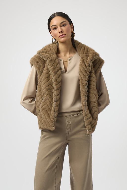 Woman wearing a beige faux fur vest with chevron pattern
