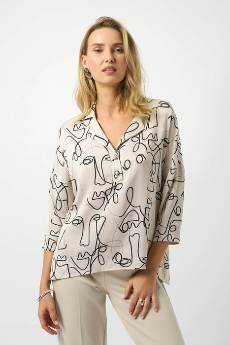 Woman wearing an abstract face patterned beige blouse with 3/4 sleeves