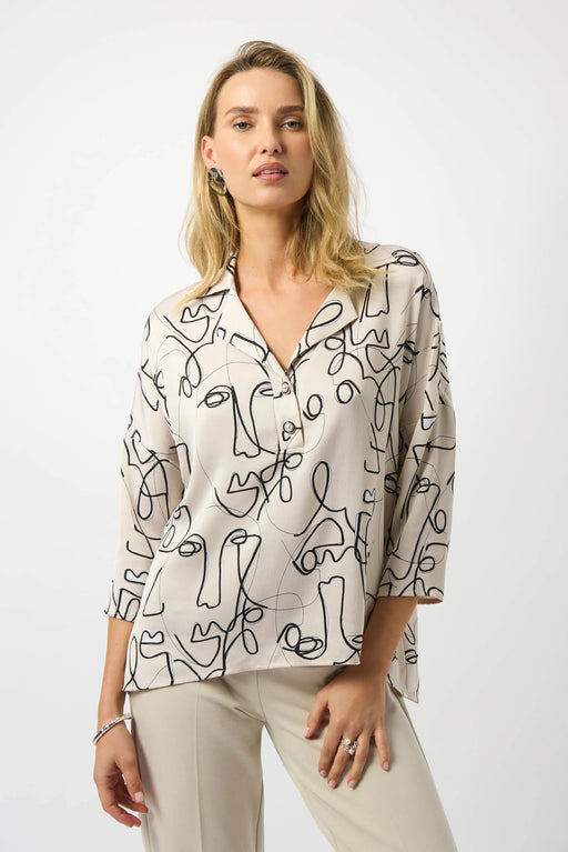 Woman wearing an abstract face patterned beige blouse with 3/4 sleeves