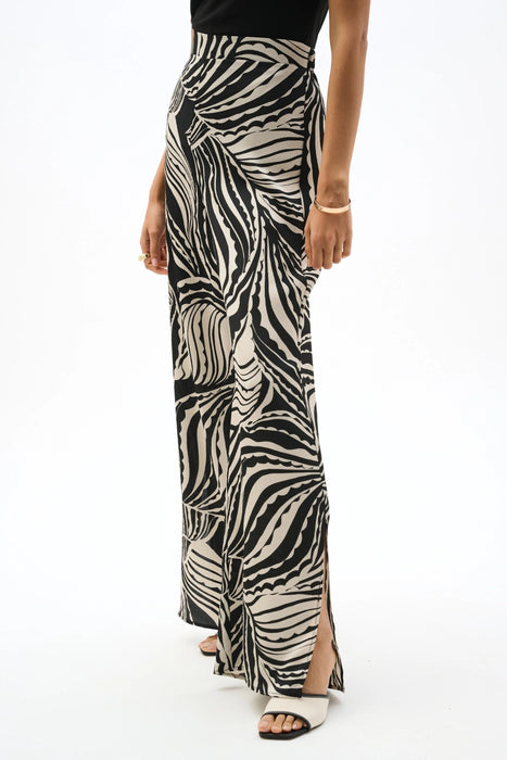 Woman wearing Joseph Ribkoff abstract print wide leg pants styled for resort wear, evening outfits, travel looks, and modern statement fashion.