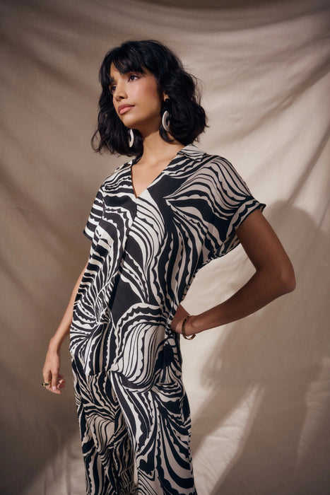 Woman wearing Joseph Ribkoff bubble satin abstract print boxy top styled for office wear, evening outings, and modern chic fashion looks.