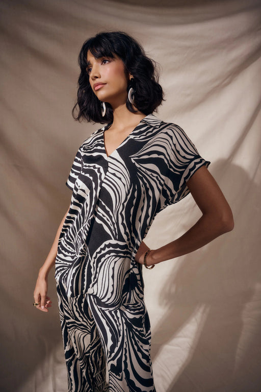 Woman wearing Joseph Ribkoff bubble satin abstract print boxy top styled for office wear, evening outings, and modern chic fashion looks.