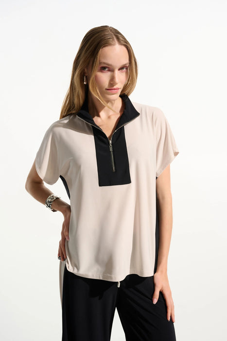 Woman wearing a beige and black two-tone color block short sleeve top with zip up front from Joseph Ribkoff